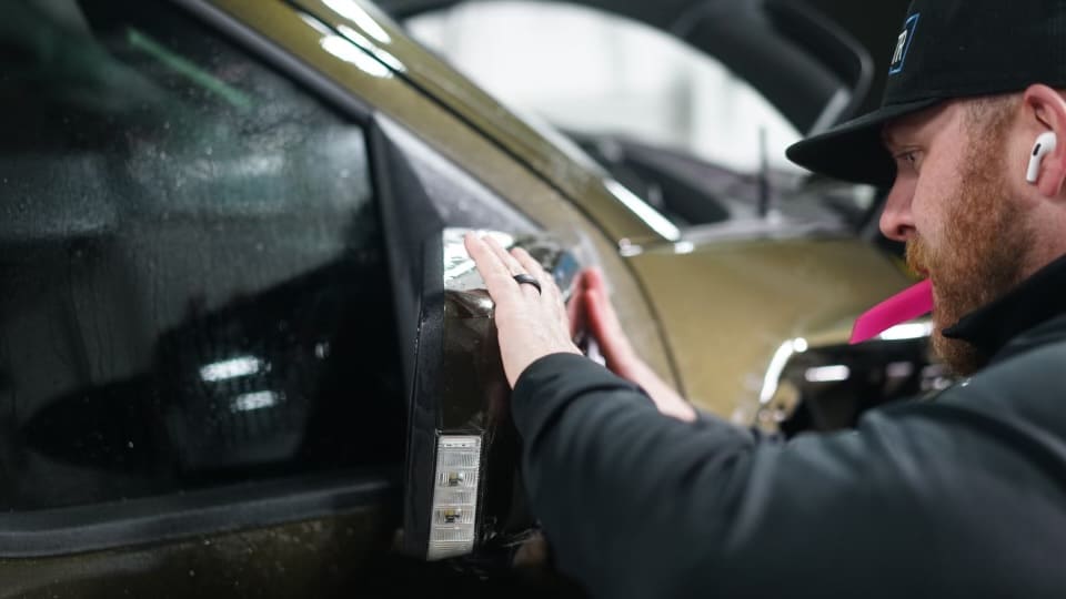 Ben at tabula rasa applying ppf on a mirror on a 2024 Ford Raptor