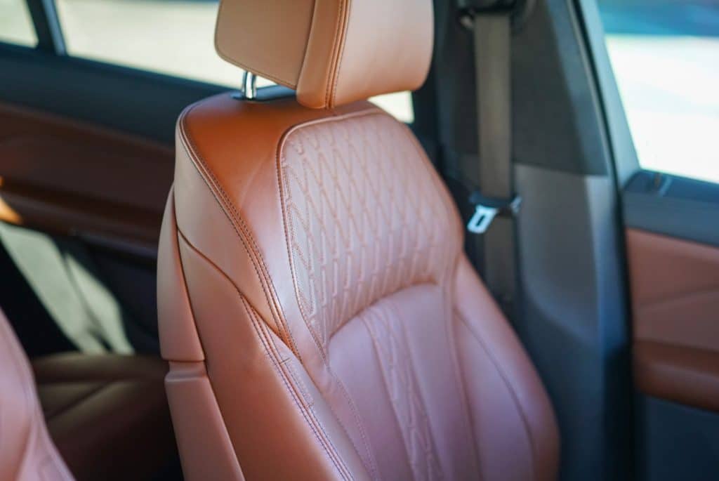 Tan leather front seat of a 2022 BMW X7 M60i after an Essential Interior detail at Tabula Rasa