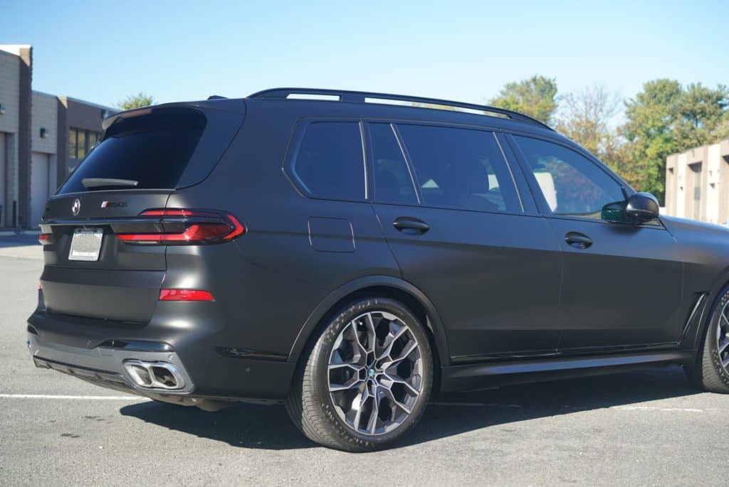 Rear three-quarter view of a BMW X7 M60i with STEK DYNOmatte Black film and STEK Final Coat ceramic